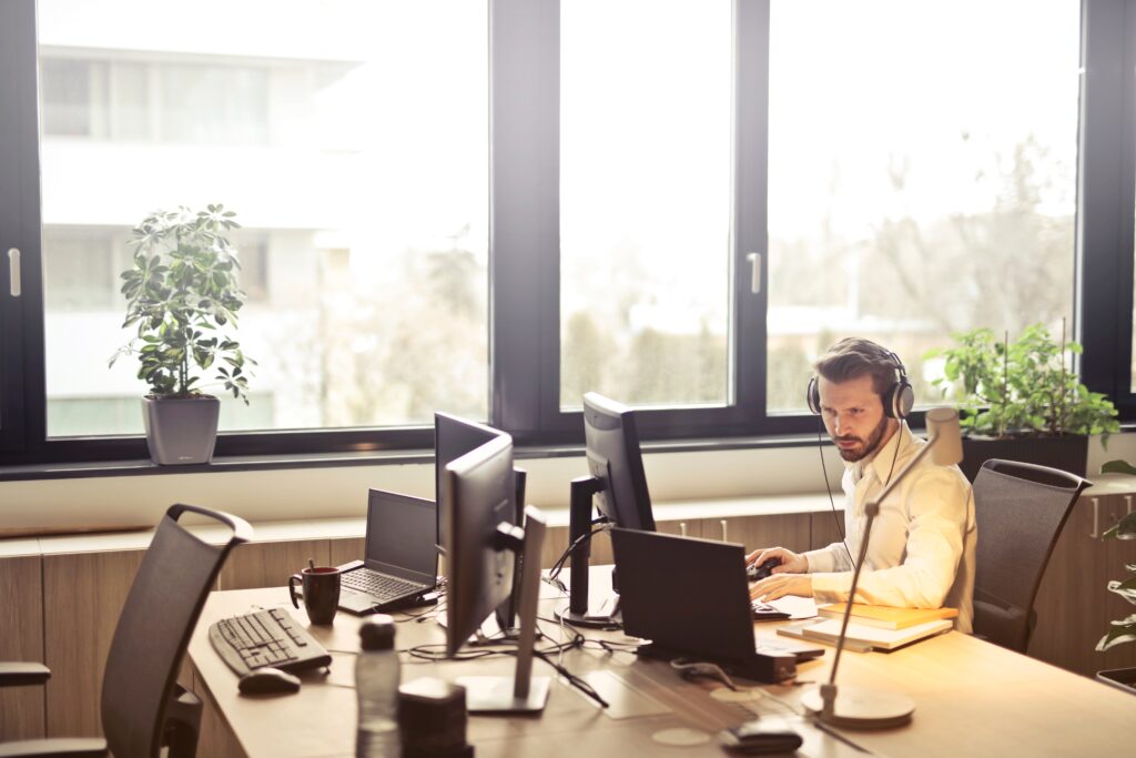 man with headphones facing computer monitor 845451